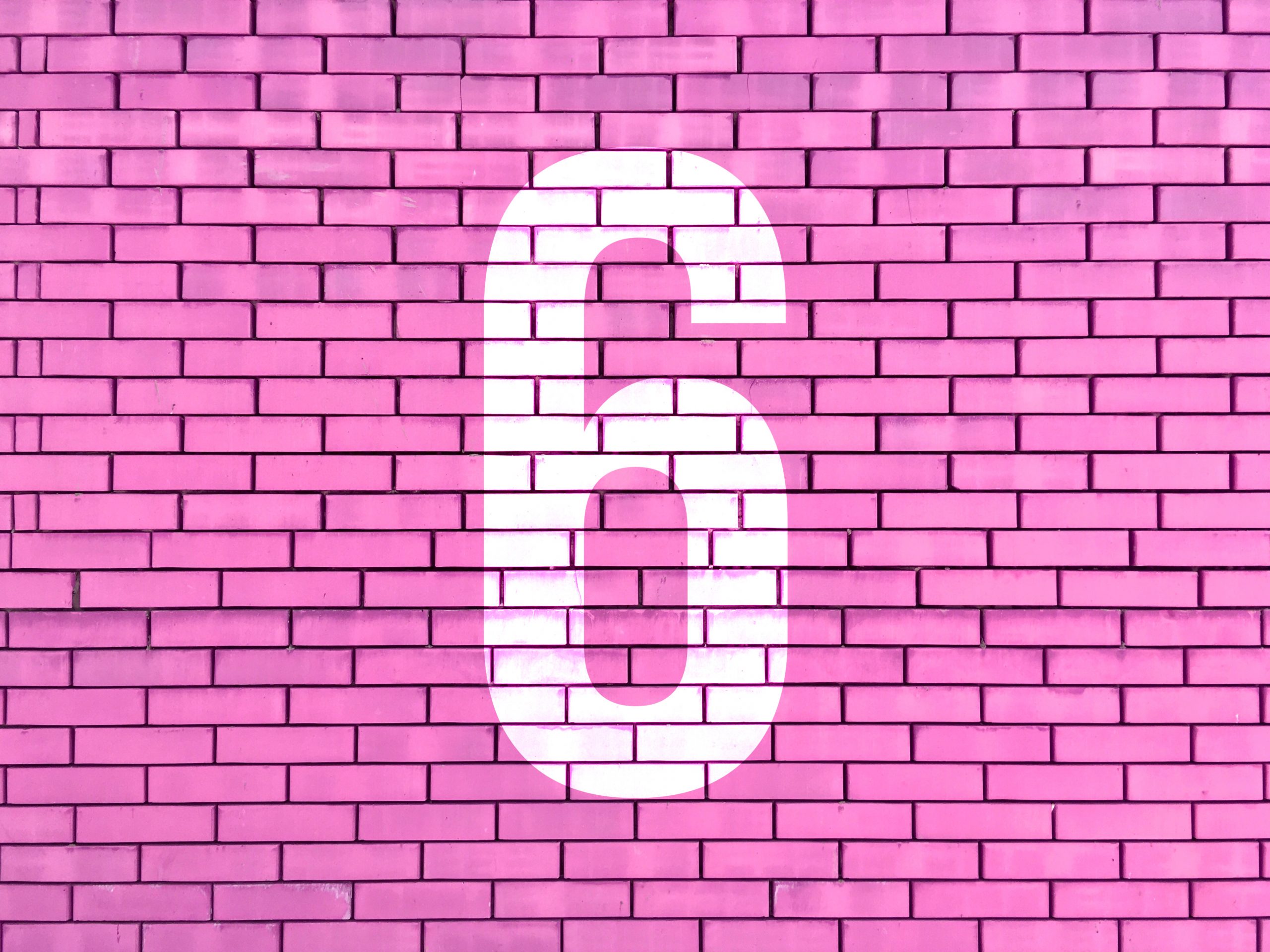 number six overlayed on pink brick background